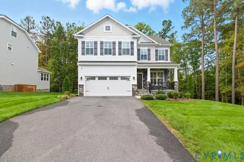 a front view of a house with a yard and trees