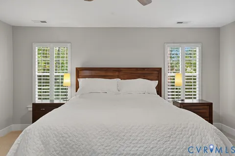 a large bed sitting in a bedroom next to a window