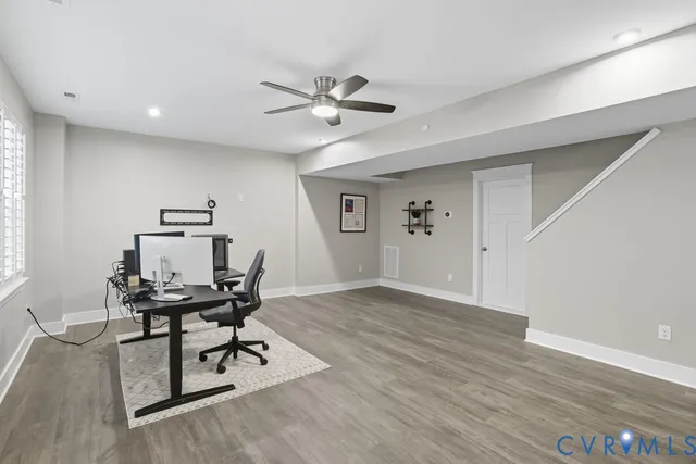 a view of a workspace with furniture and wooden floor
