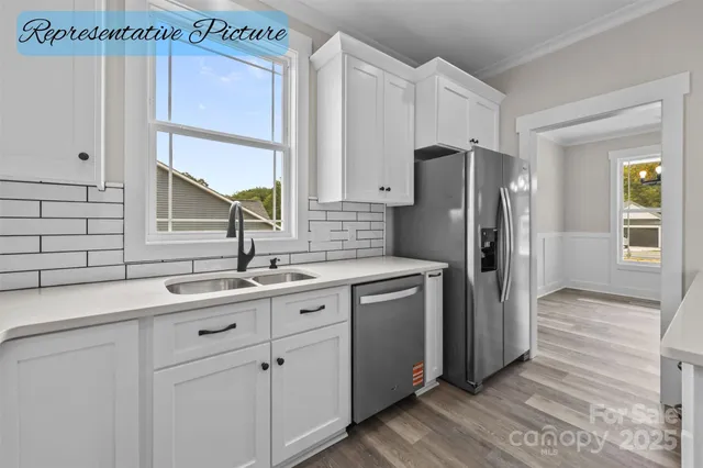 a kitchen with stainless steel appliances a sink cabinets and a window