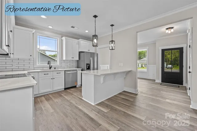 a large white kitchen with cabinets a sink and appliances