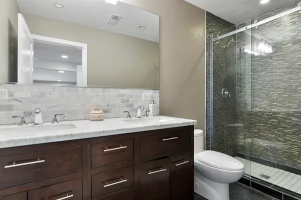 a bathroom with a granite countertop sink toilet and shower