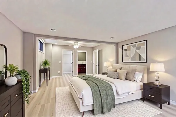 a spacious bedroom with a bed and lamp