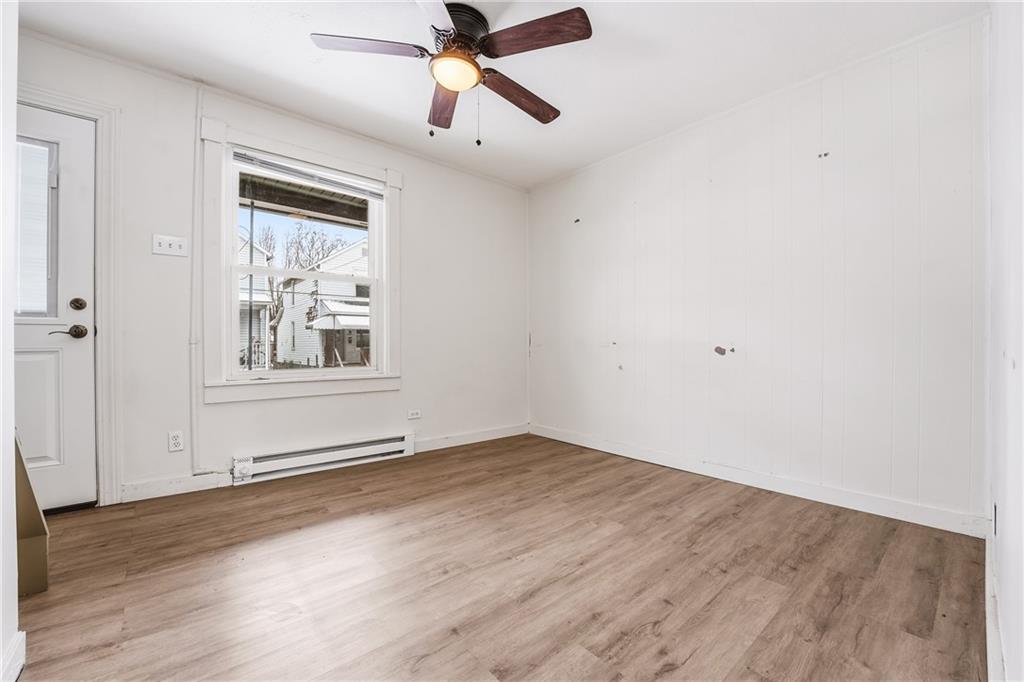 316 Mitchell Avenue Butler, PA 16001 - Photo 6 of 20 an empty room with wooden floor ceiling fan and windows