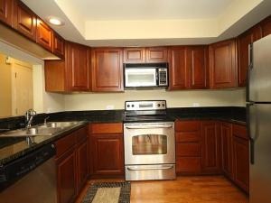 43 Foxcroft Road, Unit 103 Naperville, IL 60565 - Photo 4 of 18 a kitchen with granite countertop a stove top oven microwave and cabinets