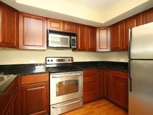 43 Foxcroft Road, Unit 103 Naperville, IL 60565 - Photo 5 of 18 a kitchen with granite countertop wooden cabinets stainless steel appliances and a window