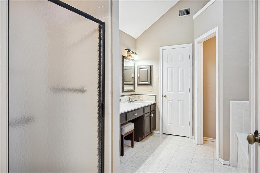 1401 Exeter Drive Plano, TX 75093 - Photo 12 of 19 Bathroom with lofted ceiling, vanity, a shower stall, and light tile patterned floors