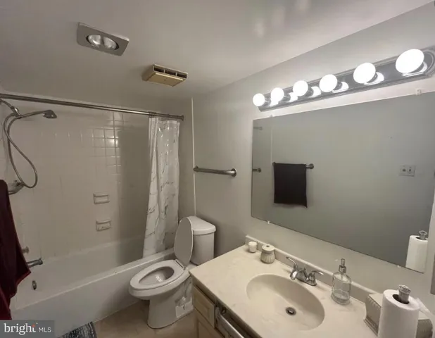 a bathroom with a sink toilet mirror and shower