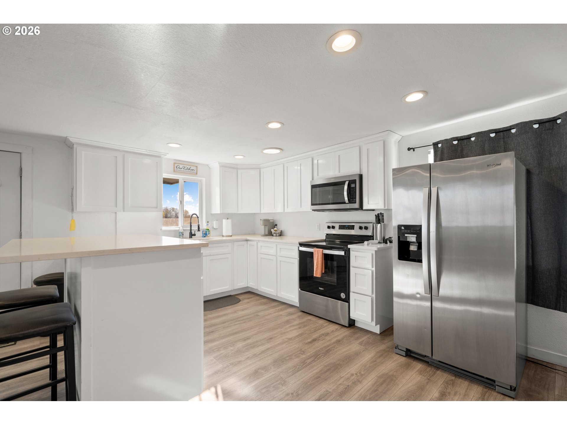 2130 Southeast 19th Street Hermiston, OR 97838 - Photo 8 of 32 a kitchen with stainless steel appliances kitchen island granite countertop a refrigerator a sink a stove top oven and white cabinets