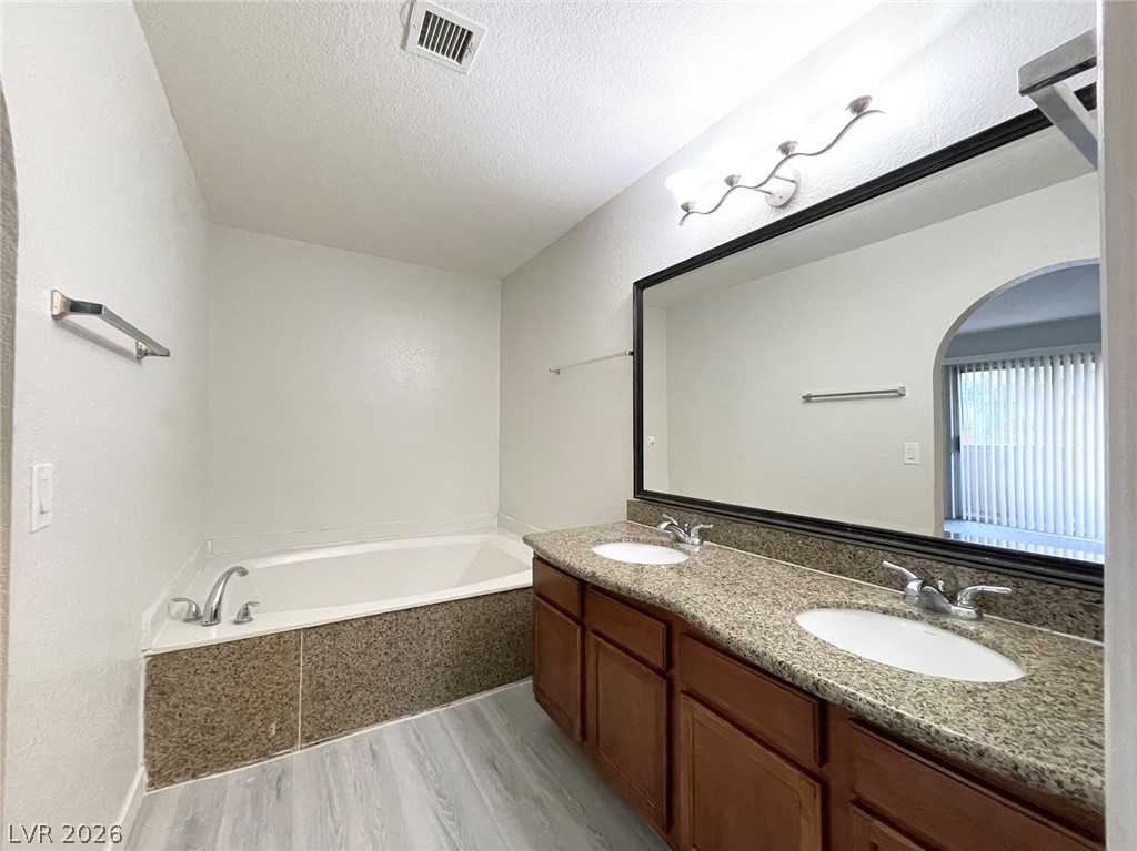 1834 North Decatur Boulevard, Unit 204 Las Vegas, NV 89108 - Photo 14 of 17 Double vanity and a deep soaking tub create a restful bathroom retreat.