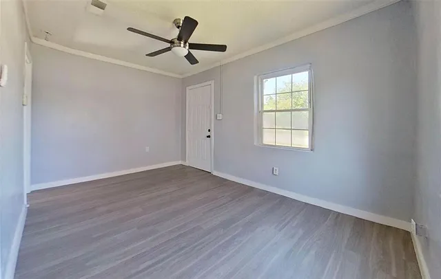 a view of a room with wooden floor and a ceiling fan