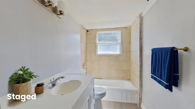 a bathroom with a tub sink and mirror