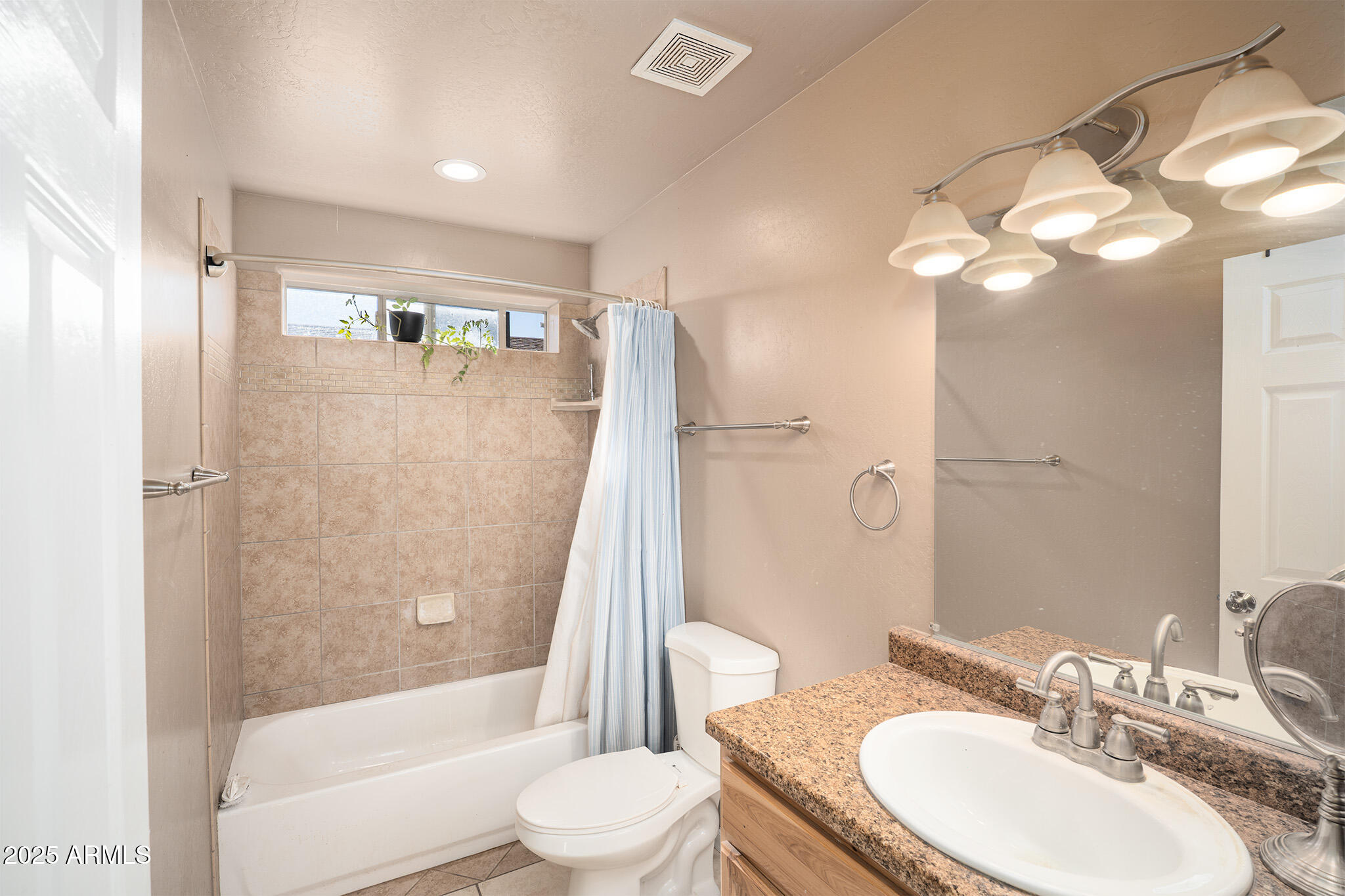 5845 North Bentley Drive Rimrock, AZ 86335 - Photo 22 of 35 a bathroom with a granite countertop sink toilet a mirror a bathtub and shower