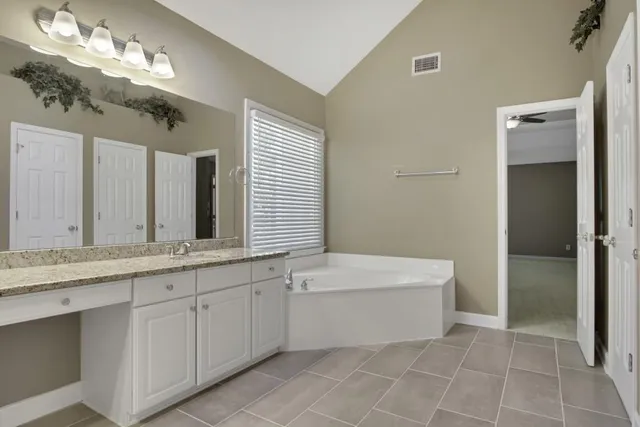 a bathroom with a tub sink and a mirror