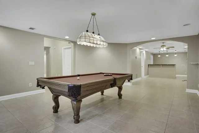 a room with pool table and wooden floor