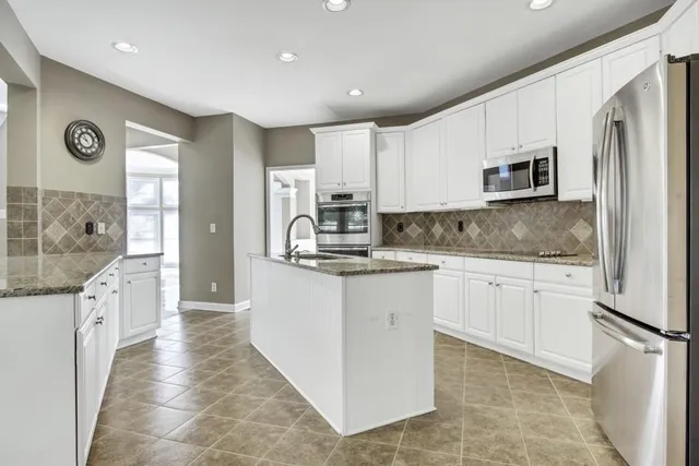a kitchen with stainless steel appliances granite countertop a refrigerator sink and stove