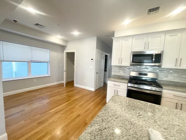 a kitchen with granite countertop a stove and a sink