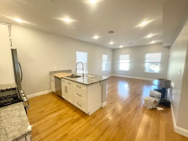 a kitchen with a sink and wooden floor