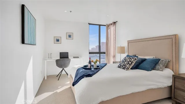 a bedroom with a bed and a potted plant next to a window