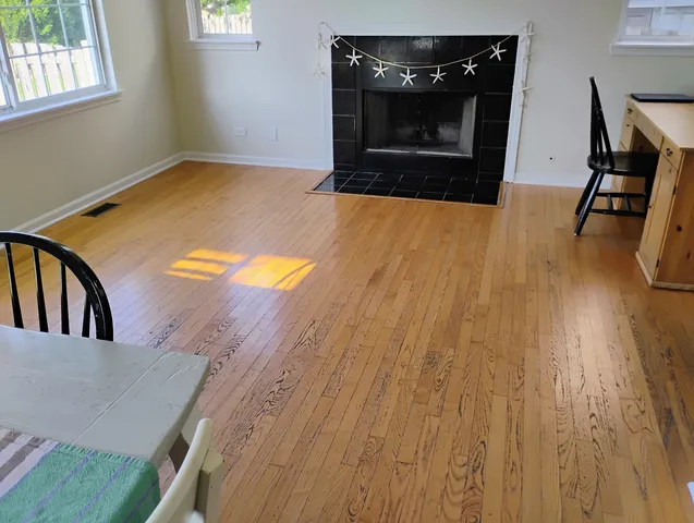 a view of a livingroom with wooden floor and a fireplace