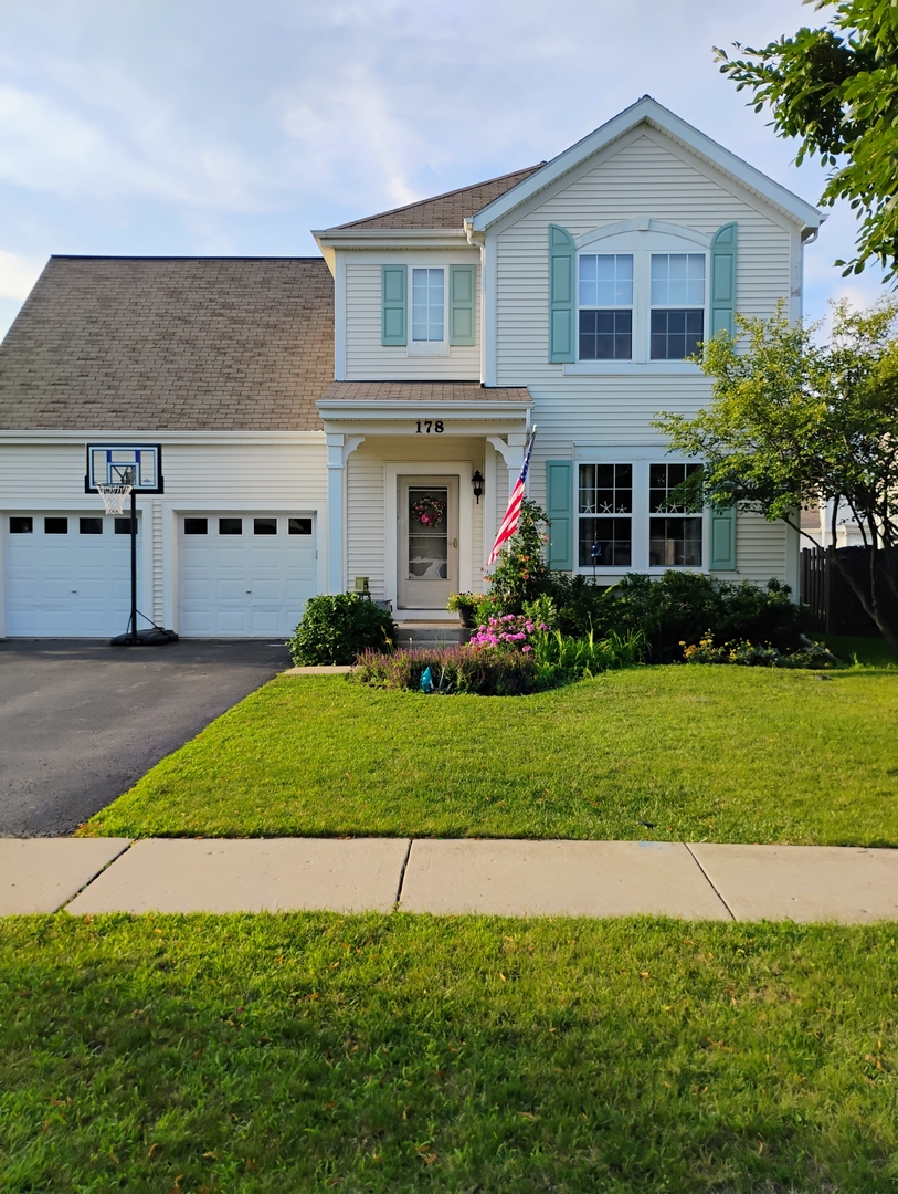 178 West Hampton Drive Round Lake, IL 60073 - Photo 3 of 55 a front view of a house with a garden and plants