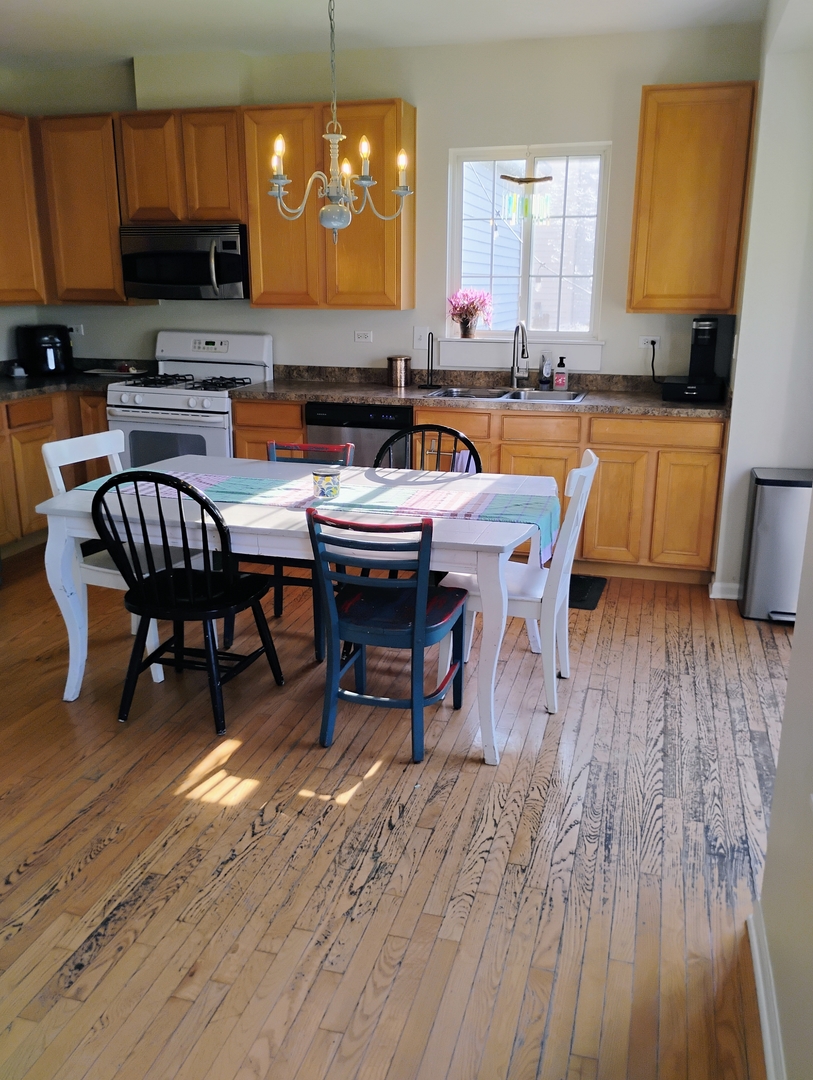 178 West Hampton Drive Round Lake, IL 60073 - Photo 7 of 55 a kitchen with stainless steel appliances a dining table chairs microwave and sink