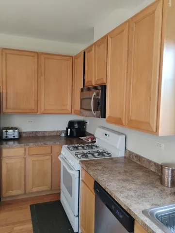a kitchen with granite countertop a sink stove and cabinets