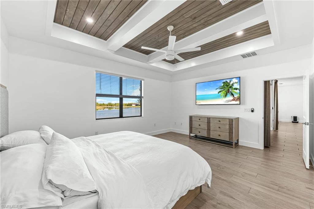 1465 Birdie Drive Naples, FL 34120 - Photo 19 of 38 a bedroom with a bed and a flat screen tv