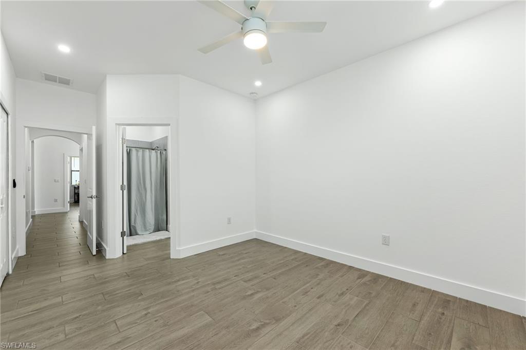 1465 Birdie Drive Naples, FL 34120 - Photo 25 of 38 an empty room with wooden floor and windows