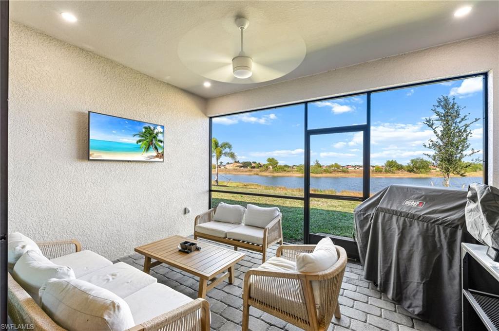 1465 Birdie Drive Naples, FL 34120 - Photo 34 of 38 a living room with furniture a floor to ceiling window and a potted plant