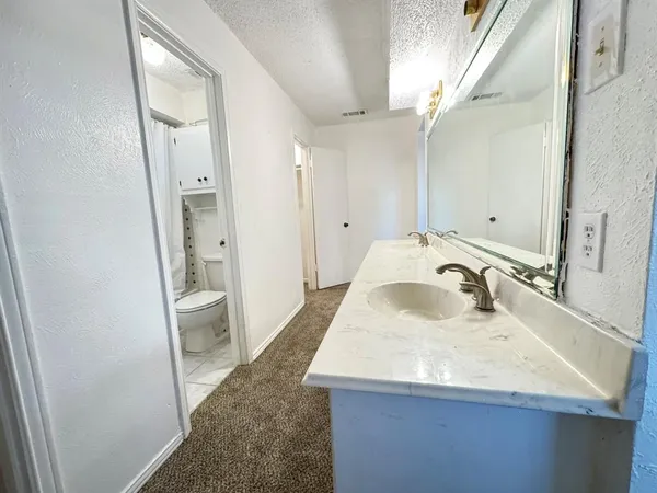 an empty room with ceiling fan and window