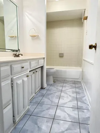 a bathroom with a granite countertop sink a toilet and a mirror