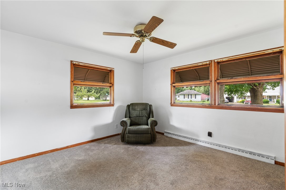 1067 Munroe Falls Kent Road Kent, OH 44240 - Photo 13 of 31 Unfurnished room featuring a baseboard radiator, carpet floors, ceiling fan, and a wealth of natural light