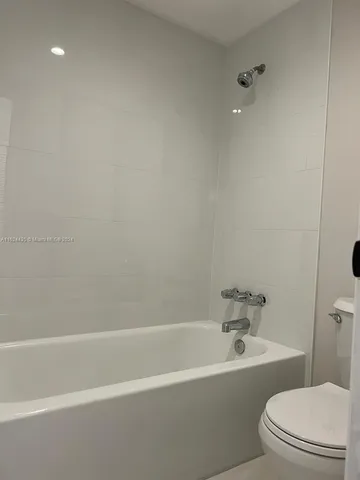 a white bath tub sitting next to a white toilet