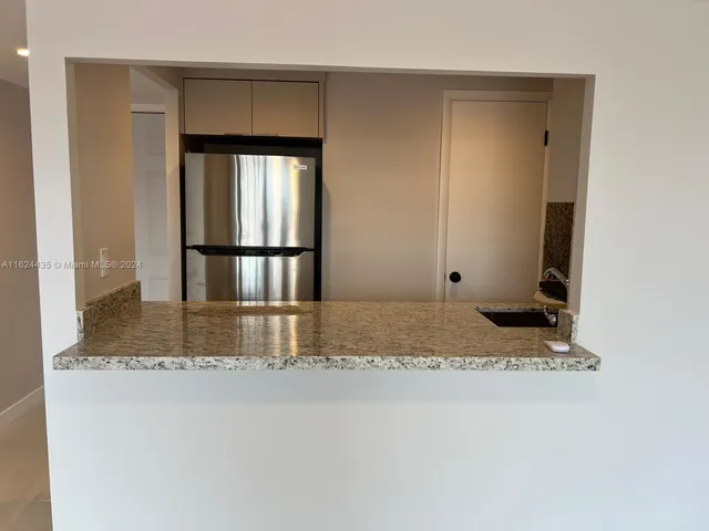 a room with a granite countertop sink and a mirror