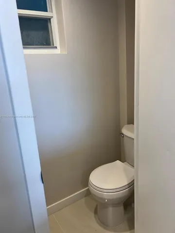 a white toilet sitting next to a shower