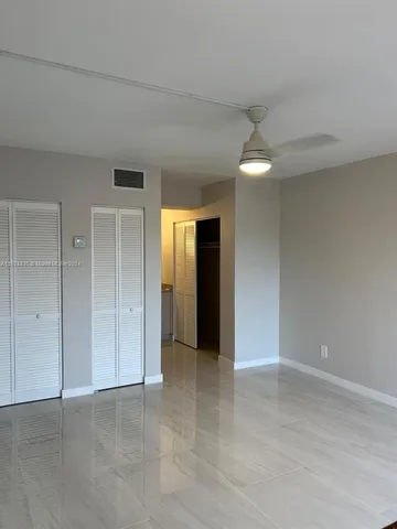 an empty room with fan and entrance