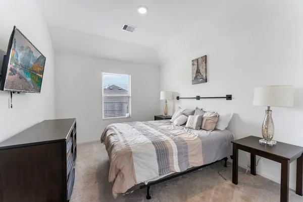 a bed sitting in a bedroom next to a window