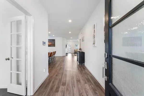 a view of a hallway with wooden floor and staircase