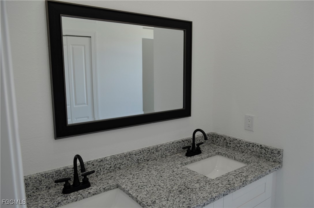 2610 34th Street West Lehigh Acres, FL 33971 - Photo 6 of 14 a close view of a sink and a mirror in a bathroom