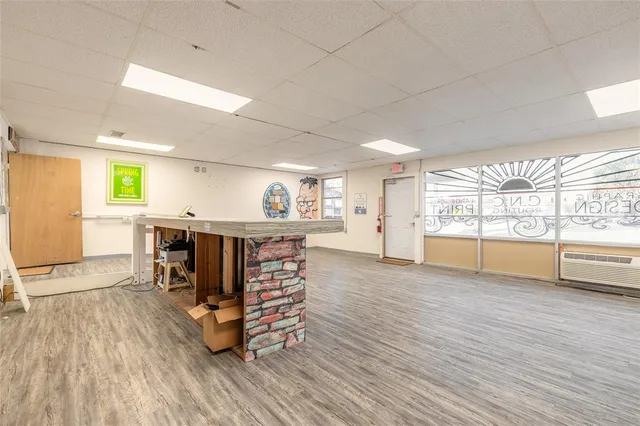 a living room with furniture a large window with kitchen view