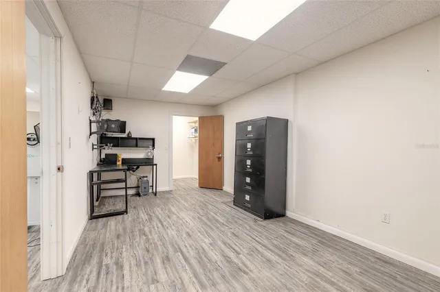 an empty room with wooden floor closet and windows