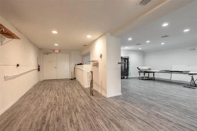 a view of a big room with wooden floor and windows
