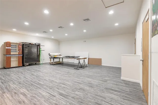 a view of an empty room with wooden floor and stairs