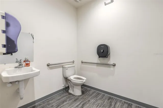 a bathroom with a sink toilet and a mirror