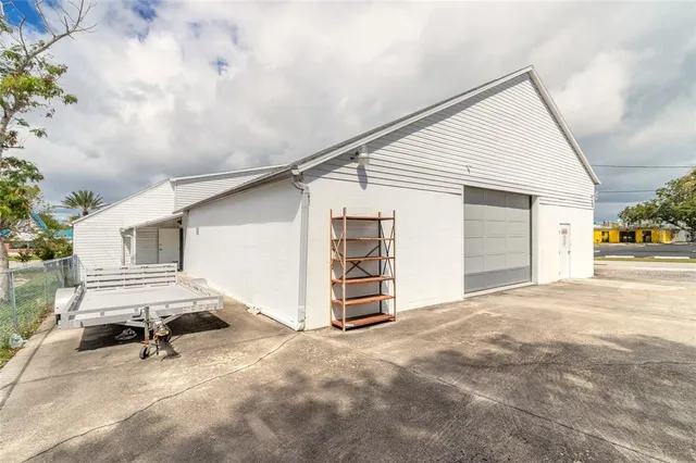 a view of a house with a barbeque and wooden stairs