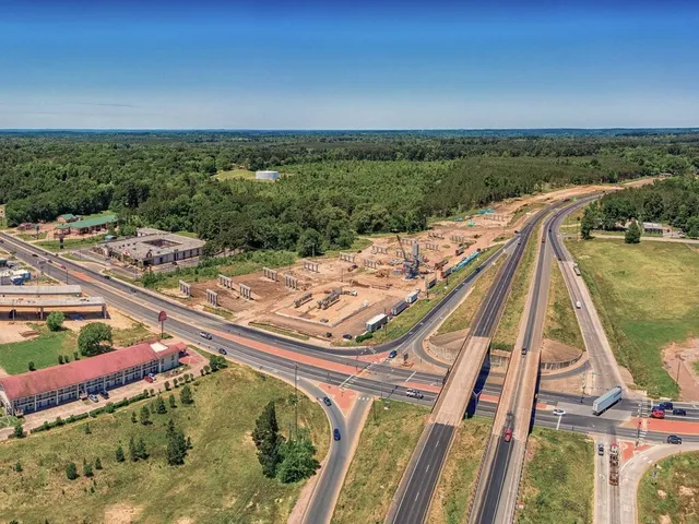 a view of a swimming pool with a yard and large trees
