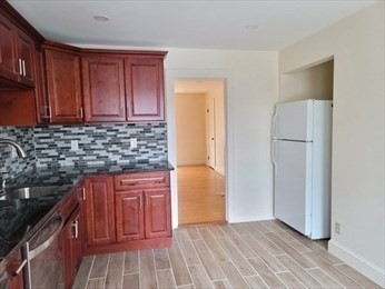 110 Clay Street, Unit 4 Quincy, MA 02170 - Photo 2 of 7 a kitchen with granite countertop wooden cabinets and a stainless steel appliances