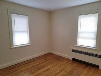 110 Clay Street, Unit 4 Quincy, MA 02170 - Photo 4 of 7 an empty room with wooden floor and windows