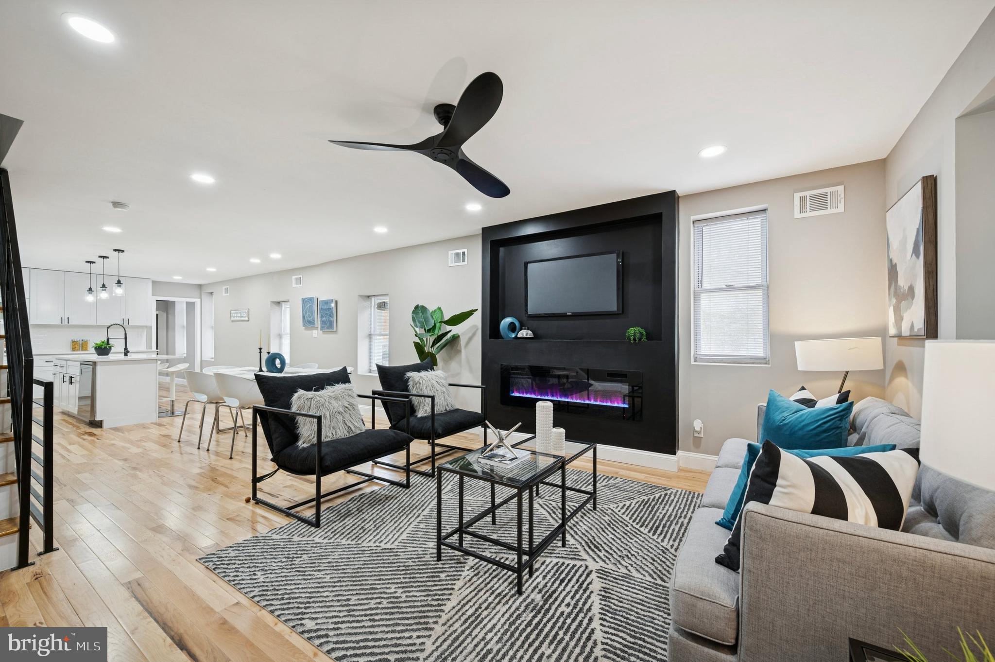 a living room with furniture a flat screen tv and a fireplace